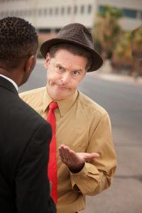 Caucasian businessman with open hand in front of African-American male