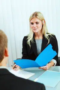 Subject: A business meeting and Interview. A human resource recruitment officer reading the file and resume of a job applicant in a job interview.
