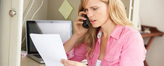 Woman Working In Home Office On Phone Discussing Document On Telephone