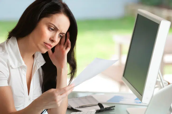 Woman looking worried reading a document