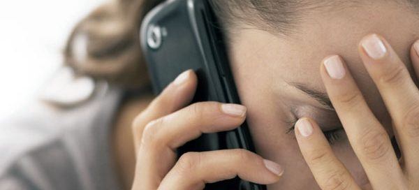 Distressed woman on the phone with debt collectors