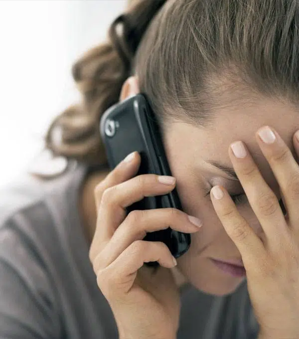 Distressed woman on the phone with debt collectors